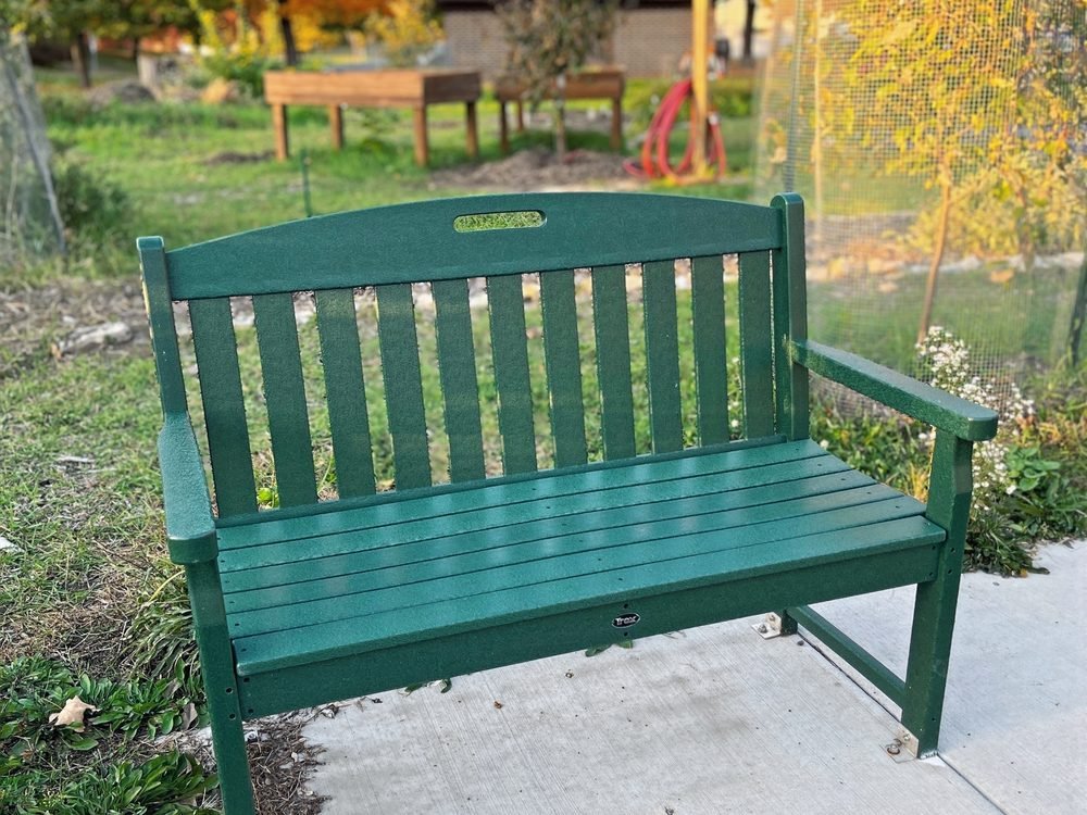 A green park bench made from recycled plastic