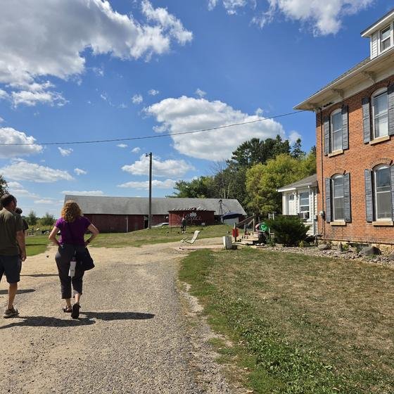 Visitors walking up the lane to the brick farmhouse at SoulSpace Farm Sanctuary