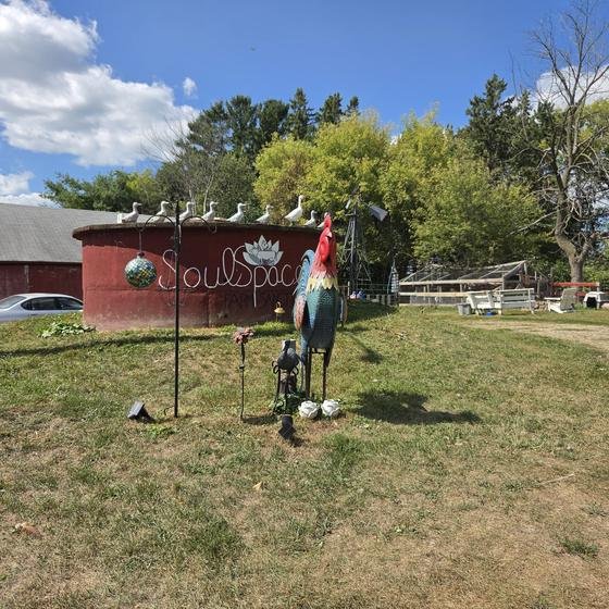 The red SoulSpace silo sign with a rooster sculpture out front